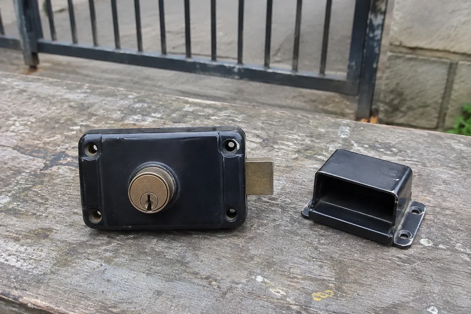 Detached rim gate lock and separate box keeper on an outdoor workbench. — Gate & Building Entry Locks, Scugog